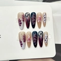 Vue détaillée des faux ongles amande avec motifs floraux bordeaux et textures papillon - Style Peinture Art Dégradé Bordeaux Noir Nude (F564)