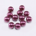 Macro detail of deep purple pearl round beads with high gloss metallic finish for DIY crafts - 6mm / Purple