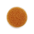 Makro-Detail von bernsteinfarbenen Glasperlen für DIY-Schmuck in einer runden Schale - 1800 Stück/Packung (2mm/18g) / Goldgelb