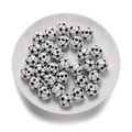 Gros plan de perles en bois motif football avec trous centraux sur une assiette blanche - Style de Football en Bois