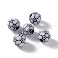 Vue macro de perles de football blanches avec étoiles et trous pour bijoux DIY - Style de Football avec des Étoiles