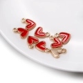 Gros plan de pendentifs cœur en émail rouge avec bordure perlée dorée pour bijoux DIY - Rouge