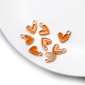 Détail macro de pendentifs cœur en émail orange avec bord perlé doré pour bijoux - Orange