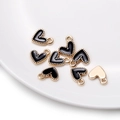 Close-up of heart-shaped gold alloy pendants with black enamel and beaded edges - 10 Pieces/Pack (9x10mm) / Black