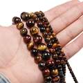 Macro detail of natural multi-color tiger eye beads in various sizes from 4mm to 12mm - 4mm / Triple Color Tiger Eye