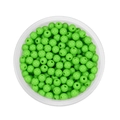 Macro shot of 6mm bright grass green acrylic round spacer beads with central holes - Green