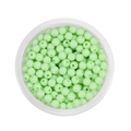 Detailed top view of 6mm light green acrylic round beads with holes in a clear container - Light Green