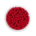 Top view of red acrylic 6mm round spacer beads with holes in a clear storage container - Red