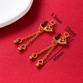 Detail of vintage gold earrings with red gems and tassels against a red textured backdrop - Gourd Hanging Red