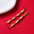 Macro view of vintage star connector with colorful enamel drip on gold finish - Oval Link Pink Blue Purple Green
