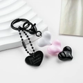 Dettaglio di perline in resina a cuore e medaglietta in metallo su portachiavi moda - Cuore Bianco Rosa Nero