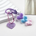 Detail of colorful resin heart beads and engraved metal tag on heart-shaped keychain - Purple Blue Pink Heart