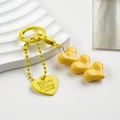 Macro detail of vibrant yellow heart-shaped beaded keychain with engraved metal tag - Yellow Heart