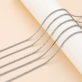 Detalle de cadena de plata para collar DIY en base blanca con iluminación suave - Estilo básico / Oro blanco
