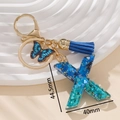 Portachiavi lettera X blu in resina glitterata con farfalla e nappina azzurra - Blu X