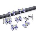 Vista dettagliata del charm a fiocco in smalto viola con strass su cinturino nero - Fiocco Blu Viola