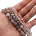 Detalle de cuentas de ágata con rayas grises en varios tamaños para crear joyería - Gris