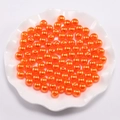 Levendige oranje ABS-parels voor DIY-sieraden in een witte decoratieve schaal - Oranje