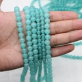Natural aquamarine chalcedony loose beads in various sizes held in hand for comparison - 4mm / Aquamarine