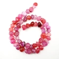 Spiraled string of pink and red irregular Dragon Vein Agate beads on white background - 10mm / Red