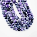 Polished natural fire agate round beads featuring unique purple and black mineral textures - Purple