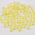 Primer plano de medias perlas ABS amarillo crema con base plana para manualidades - Amarillo claro