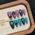 Unghie finte stiletto cat-eye con farfalle e catene d'argento nei colori viola e blu - XS
