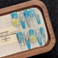 Blue cat-eye press-on nails with 3D water ripples and yellow flower art on wooden tray - L / Blue