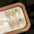 Lange stiletto plaknagels met champagne glitterverloop en blauwe edelstenen - XS / Dunne Stiletto Stijl