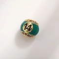 Macro shot of green enamel billiard ball charm with number 14 and cubic zirconia - Number 14 Billiard Style