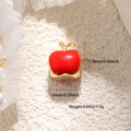 Dettaglio di ciondolo mela in smalto rosso e base dorata con dimensioni di 10x11,8mm - Ciondolo Mela (A0696)
