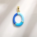Golden oval pendant with blue enamel color blocking and elegant metallic finish - Letter O