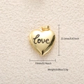 Foto macro de un relicario de corazón dorado con grabado 'Love' y dimensiones - Estilo Relicario Corazón Love Oro (A0787)