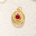 Macro detail of oval gold-plated tulip pendant featuring a deep red teardrop stone - Red Tulip
