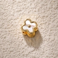 Macro view of gold-plated clover charm with white mother-of-pearl inlay and hollow design - Black White Shell Flower