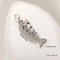 Macro shot of silver flexible koi fish pendant with red zircon eye and scaled texture - Silver 6-Section Fish (A0841)