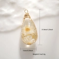 Macro detail of drop resin pendant with white dried flowers and gold wire wrap - Transparent Resin White Daisy Dried Flower Style