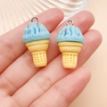 Detail view of blue resin ice cream cone charms with silver rings held in hand - Resin Food Play Ice Cream Cone (24761) / Lake Blue