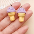 Close-up of resin ice cream cone pendants in purple and yellow with silver eyelet hooks - Resin Food Play Ice Cream Cone (24764) / Purple