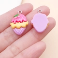Detail of a pink and yellow resin ice cream charm held by hand for size reference - Purple Rose Red Cherry Cone Style (24478)