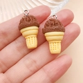 Close-up of resin chocolate ice cream cone charms with silver metal rings held in hand - Resin Food Play Ice Cream Cone (24765) / Coffee Brown