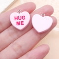 Détail de pendentifs cœur en résine rose avec texte HUG ME rouge pour bijoux DIY - Rose HUG ME (24525)