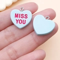 Gros plan de pendentifs cœur en résine bleu clair avec texte Miss You pour bijoux DIY - Bleu Lac MISS YOU (24533)