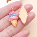 Hand holding a colorful DIY resin strawberry ice cream pendant for craft accessory making - Yellow Ice Cream (24489)