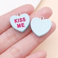 Nahaufnahme der blauen Harz-Herzanhänger mit KISS ME Text und Metallringen für DIY - Seeblauer Kissme-Stil