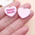 Macro shot of pink resin heart pendants with Sweet Heart text and metal ring - Pink Sweet Heart Style (24508)