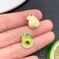 Détail de breloques avocat en émail montrant la face fruit vert et le dos doré texturé - Style Avocat (24424) / 15x11x1mm
