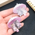 Detalle del colgante de acrílico con dos gatitos bajo un paraguas rosa para bricolaje - Gato Morado con Paraguas (24015)