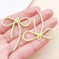 Dettaglio dei ciondoli a fiocco verde chiaro con trama a coste e anello di aggancio - 42x37mm / Giallo chiaro