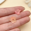Close-up of frosted acrylic trumpet flower beads held on fingertips for DIY jewelry making - Trumpet Flower (22014) / 1 Piece (12x7mm) / Orange Pink Gradient
